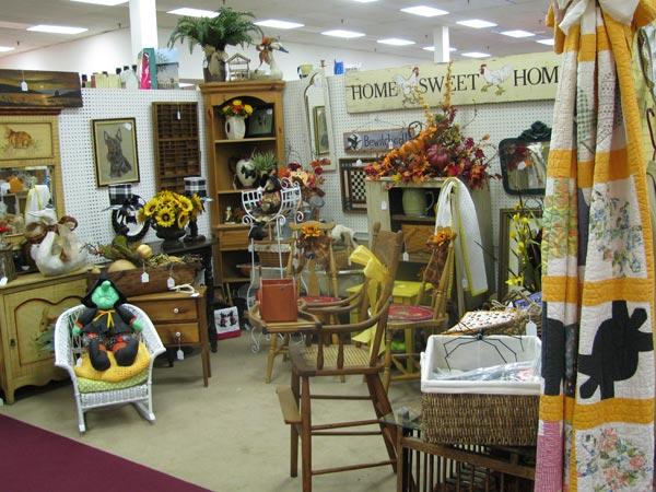Home decor and vintage furniture booth inside St Charles Antique Mall with chairs, shelves, and seasonal decorations