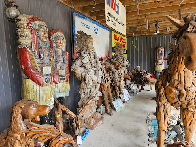 Large wooden Native American carvings and rustic sculptures displayed outside vendor booth at Highway Pickers Antique Mall