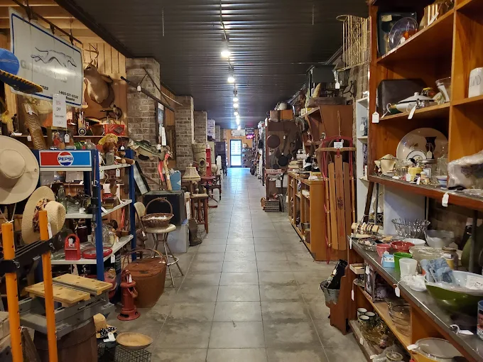 Long aisle of vendor booths filled with antiques and collectibles at Highway Pickers indoor flea market