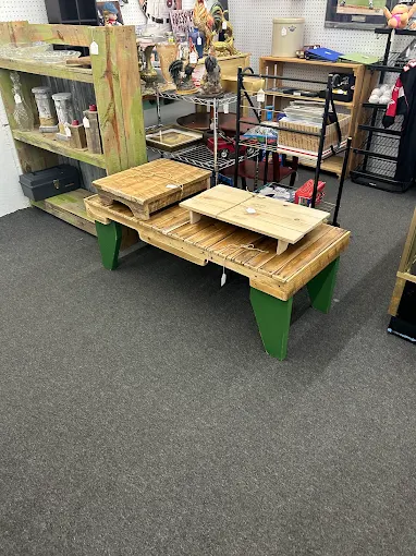 Handcrafted wooden furniture and rustic antique pieces displayed in a vendor section at Timeless Antiques & Flea Mall in Valley Alabama.
