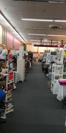 Wide interior aisles with multiple vendor booths inside Timeless Antiques & Flea Mall in Valley Alabama.