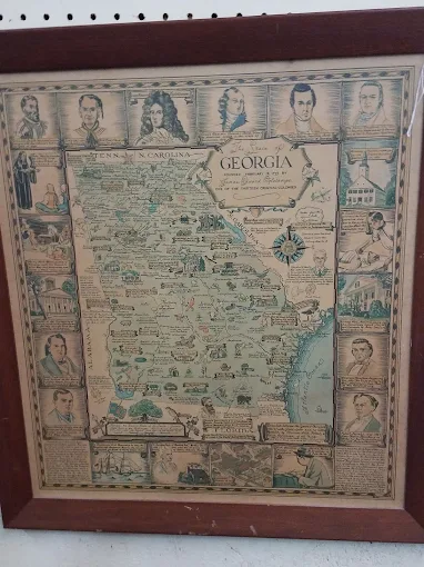 Framed vintage map of Georgia displayed among antique prints at Timeless Antiques & Flea Mall in Valley Alabama.