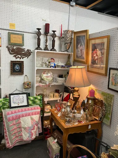 Vendor booth featuring vintage home décor, antique lamps, framed artwork, and collectibles at Timeless Antiques & Flea Mall in Valley Alabama.