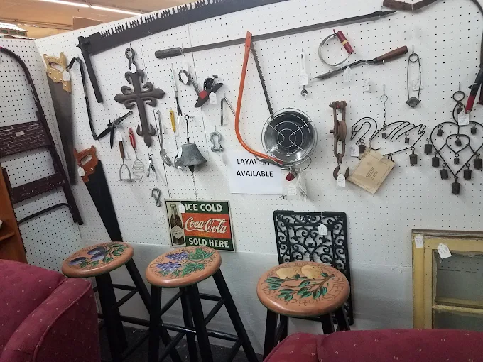 Vintage tools, antique wall décor, and bar stools displayed inside Timeless Antiques & Flea Mall in Valley Alabama.