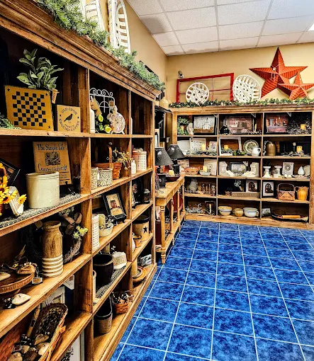 Shelves of rustic decor, pottery, and vintage collectibles displayed inside Two Crows Antique Mall in Ranson WV.