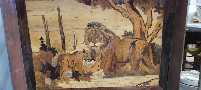 Vintage lion artwork and framed antique wall decor displayed inside Two Crows Antique Mall in Ranson West Virginia.
