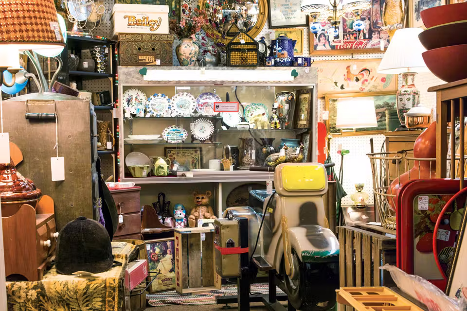 Antique furniture and vintage décor displayed inside Maumee Antique Mall with organized dealer booths and wide indoor aisles.