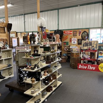 Independent dealer booths and collectible display cases inside Maumee Antique Mall featuring antiques, jewelry, and vintage finds.