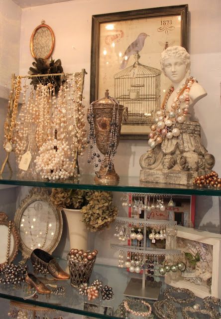 Independent dealer booths and collectible display cases inside Maumee Antique Mall featuring antiques, jewelry, and vintage finds.