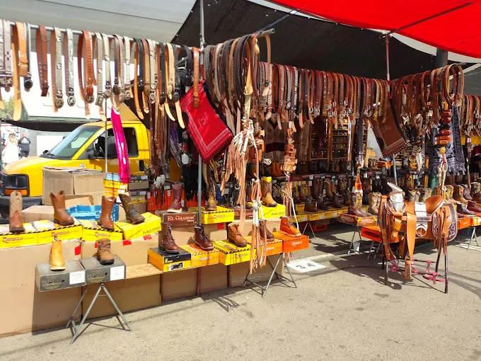 Vendor stalls selling leather goods and boots at Cherry Avenue Auction Fresno outdoor flea market