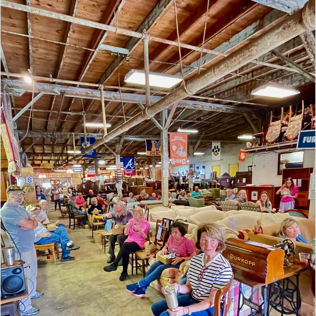 Visitors browsing antique furniture and vintage collectibles at the Historic Macon Spring Flea Market in Macon Georgia