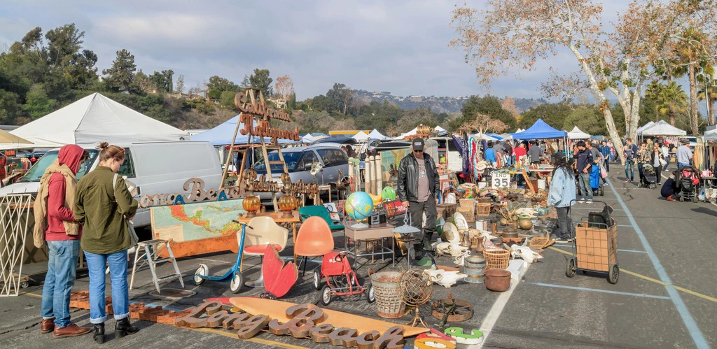 Shoppers browsing vintage clothing racks at Silverlake Flea Market in Los Angeles