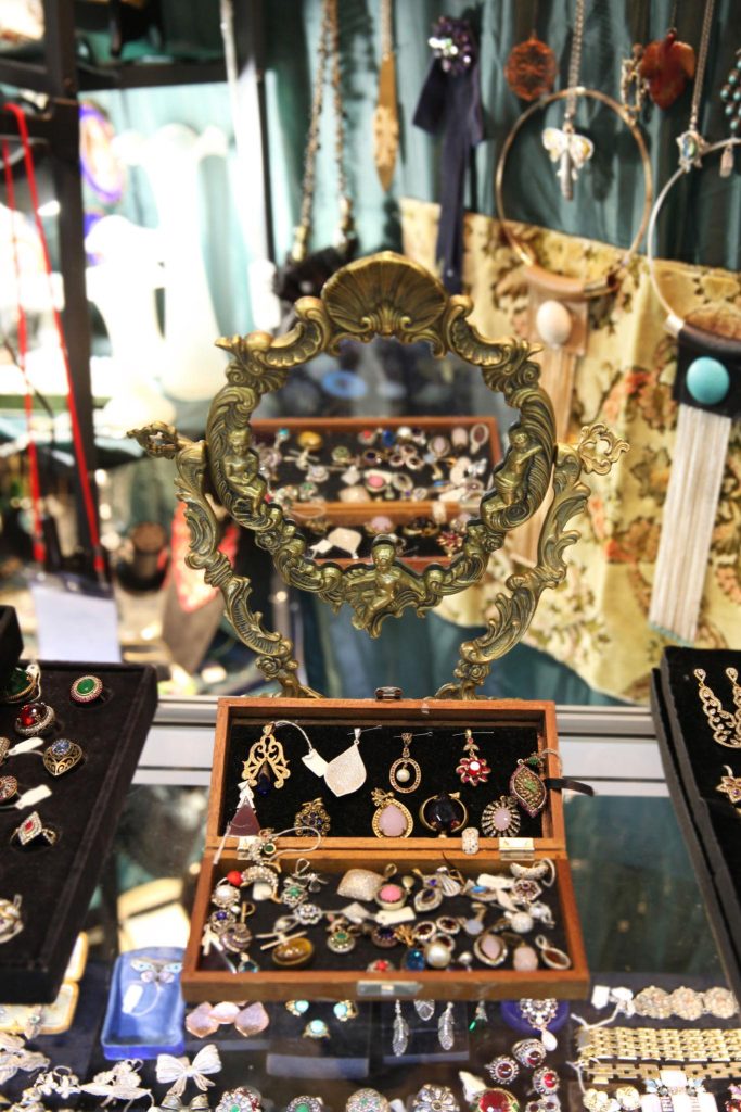 Vintage jewelry and antique glassware displayed in locked cases at an Ohio antique store