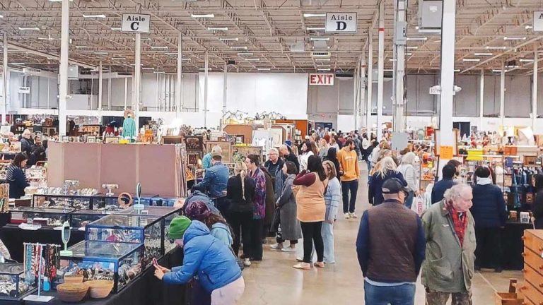 Crowds browsing antique booths at the DC Big Flea Antiques Event indoor flea market at Manassas Mall in Manassas Virginia.