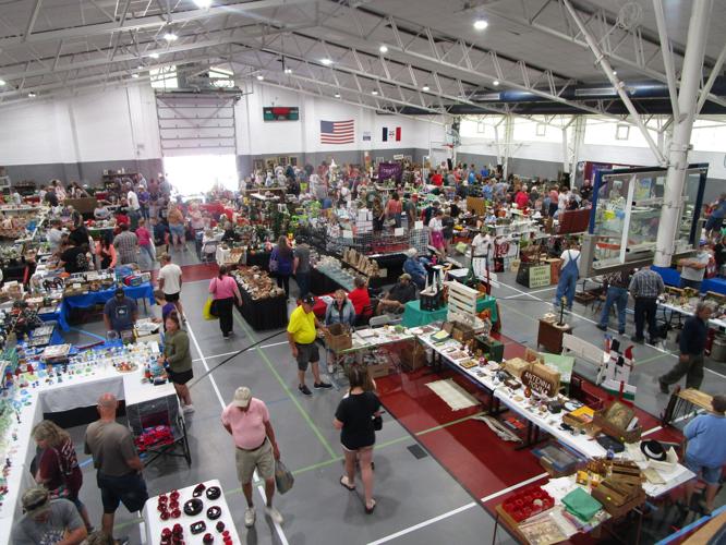 Indoor vendors and shoppers at the Monticello Flea Market antique and collectible show at Jones County Fairgrounds in Monticello Iowa