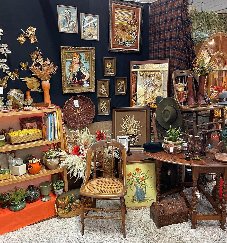 Multi-vendor antique mall booths displaying vintage furniture, glassware, and collectibles in Ohio