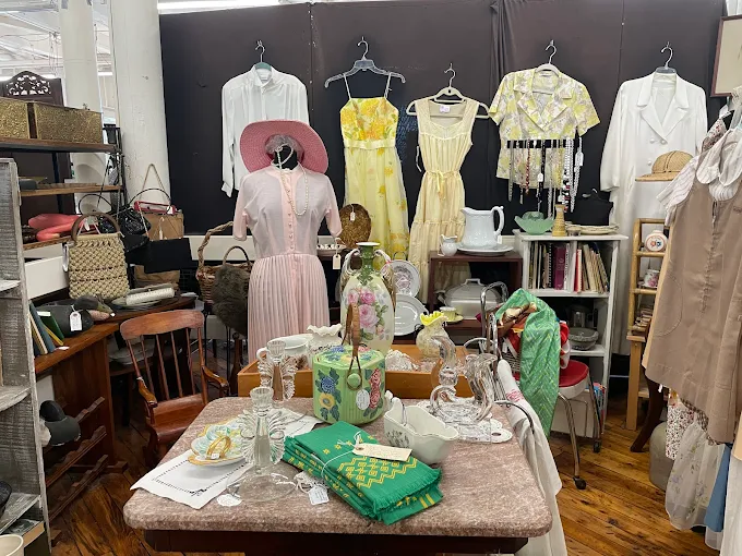 Vintage clothing, antique glassware, ceramics, and collectibles displayed inside Cabot Mill Antiques in the historic Fort Andross mill, Brunswick, Maine.